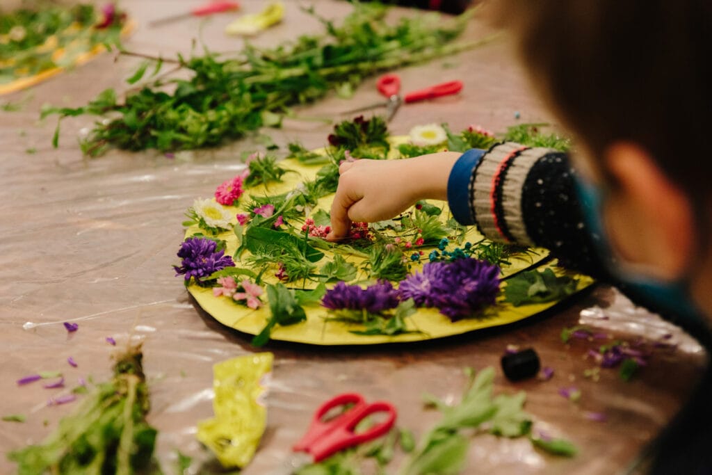 παιδί που φτιάχνει χειροτεχνία με λουλούδια