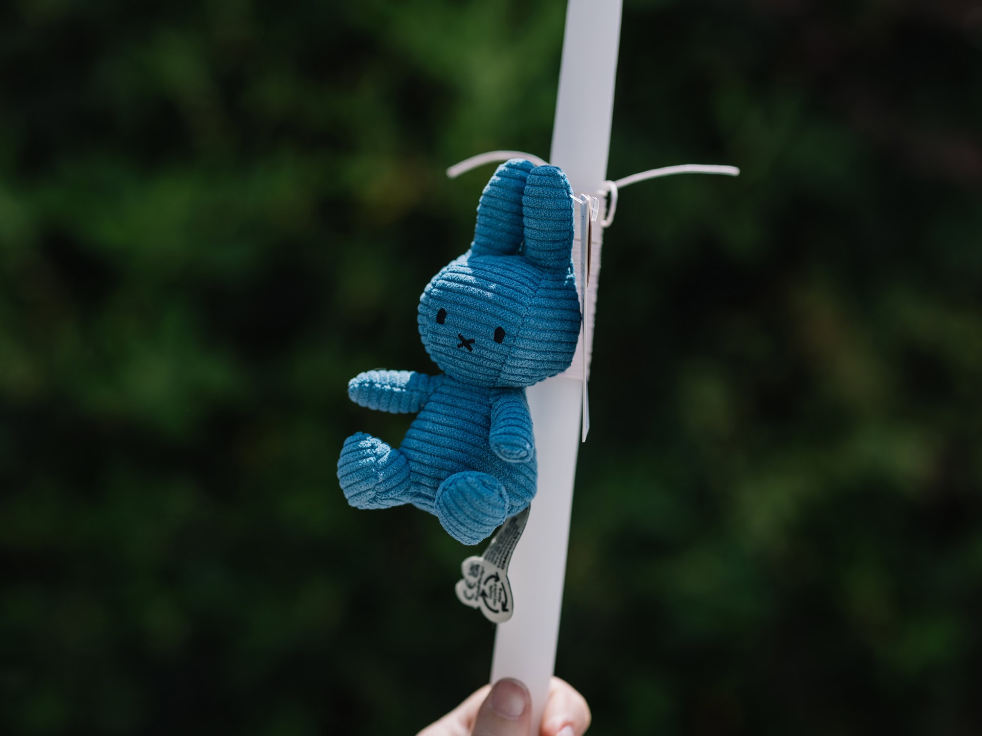 Candle with a blue stuffed bunny key chain.